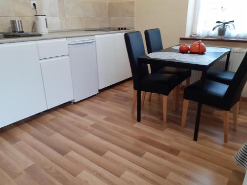 a kitchen and dining room with a table and chairs at Apartamenty Kaskada in Miedzygorze