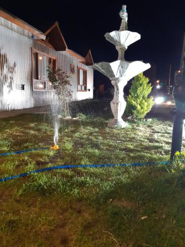 a water fountain in a yard at night at Che Cauquen in Puerto Santa Cruz