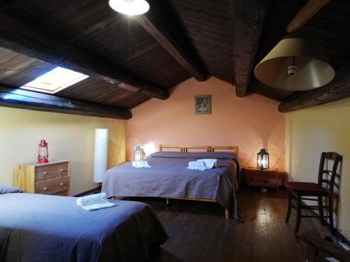 een slaapkamer met 2 bedden en een houten plafond bij Casale degli Zappini in Castiglione di Sicilia