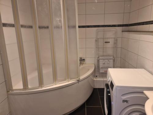 a white bathroom with a tub and a toilet at GSS18 1-OG Möblierte Wohnung in Oebisfelde in Oebisfelde