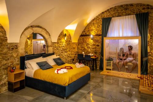 a bedroom with a bed and two women sitting on a patio at La Rondine in Tagliacozzo