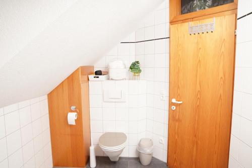 ein Badezimmer mit einem WC und einer Holztür in der Unterkunft gemütliche Wohnung in Hohenems in Hohenems