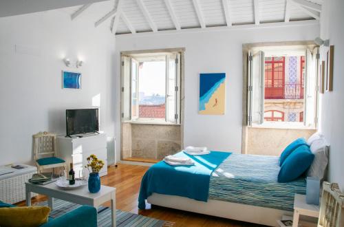 1 dormitorio con 1 cama azul y 2 ventanas en Olival 54 Apartments, en Oporto