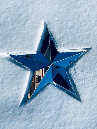 a large blue star laying in the snow at Hôtel 16 | 150 Montagne & Spa Nuxe in Vars