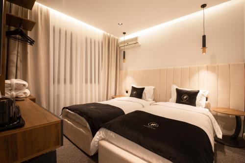 a hotel room with two beds in a room at Plaza Boutique Hotel in Pristina
