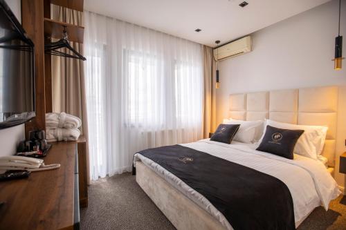 a bedroom with a large bed and a television at Plaza Boutique Hotel in Pristina