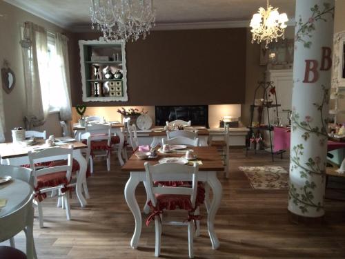 a dining room with tables and chairs and a chandelier at B&B Sul Garda in Castelnuovo del Garda