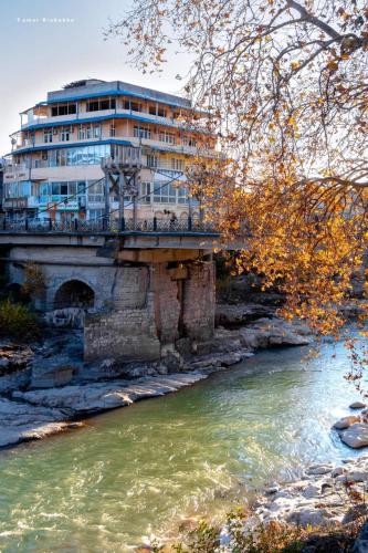 a building sitting on top of a bridge over a river at Excellent Hostel Kutaisi in Kutaisi