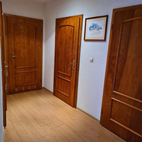 Habitación vacía con 2 puertas de madera y suelo de madera. en Restauracja Joanna, en Gogolin