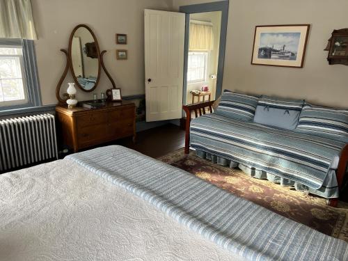 a bedroom with two beds and a mirror at Shoreham Inn Bed & Breakfast in Shoreham