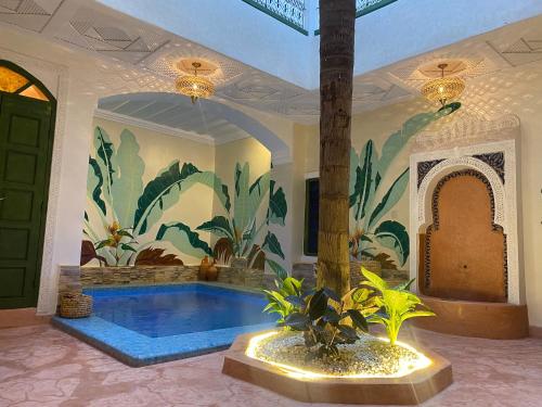 einen Pool in einem Haus mit Wandgemälde in der Unterkunft Riad Celia in Marrakesch