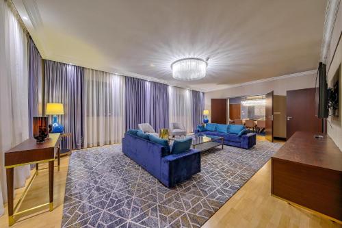 a living room with two blue couches and a table at InterContinental Warszawa by IHG in Warsaw