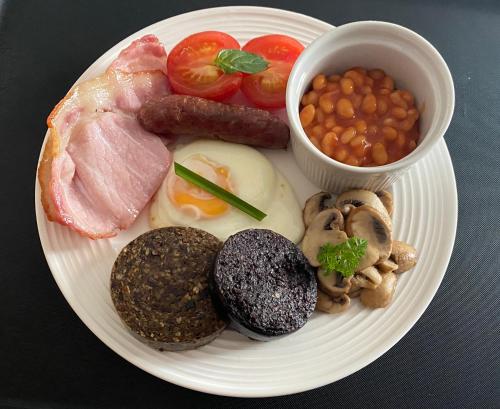 a plate of food with eggs sausage beans and mushrooms at Garden Park Guest House in Grantown on Spey