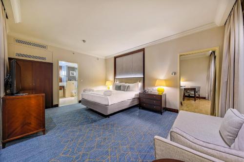 a bedroom with a bed and a tv and a couch at InterContinental Warszawa by IHG in Warsaw