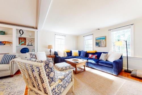 a living room with a blue couch and chairs at Pleasant Bay Retreat in Orleans