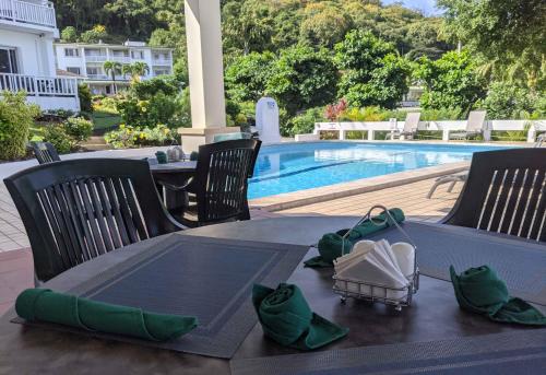 a table with green napkins on it next to a pool at Siesta Hotel in Morne Rouge