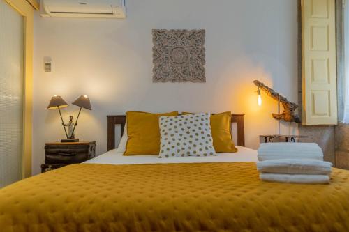 a bed with a white comforter and pillows on it at Casa Sá Noronha Old Town in Porto