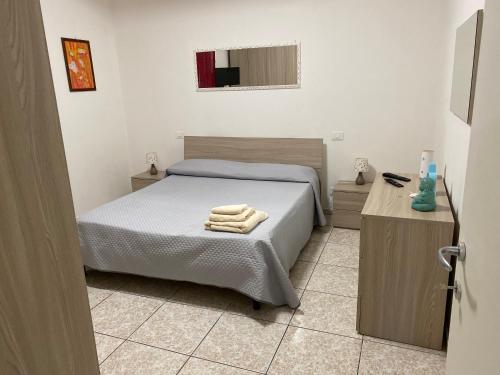 een slaapkamer met een bed met handdoeken erop bij AG sweet apartment in Reggio di Calabria