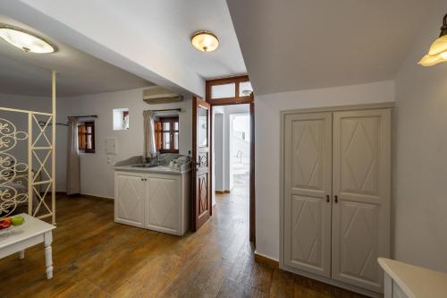 a kitchen with white walls and wooden floors at Smaro Studios in Firostefani