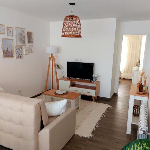 ein Wohnzimmer mit einem weißen Sofa und einem TV in der Unterkunft Espacio arredondo castelar in Castelar