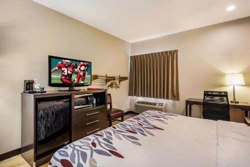 a hotel room with a bed and a flat screen tv at Red Roof Inn St Louis - Troy, IL in Troy