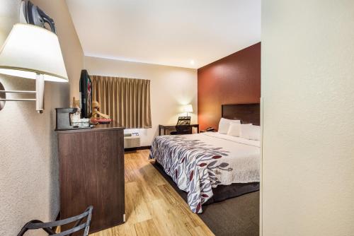 um quarto de hotel com uma cama e uma televisão de ecrã plano em Red Roof Inn St Louis - Troy, IL em Troy