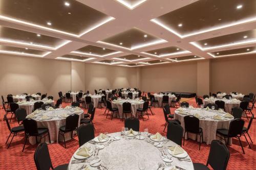 a banquet hall with tables and chairs with white linens at Camino Real Mérida in Mérida