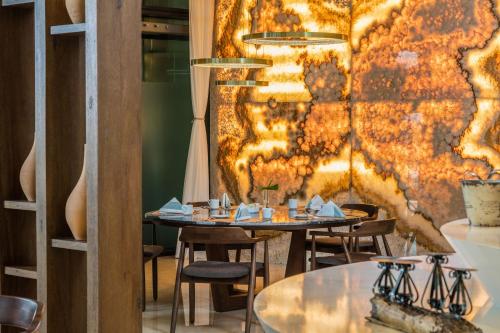 a restaurant with tables and chairs and a wall at Camino Real Mérida in Mérida