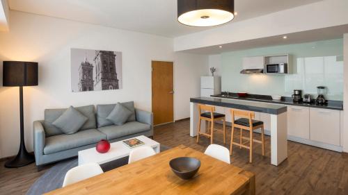 a living room and kitchen with a couch and a table at Camino Real Puebla Angelopolis in Puebla