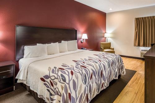 a hotel room with a bed and a chair at Red Roof Inn St Louis - Troy, IL in Troy