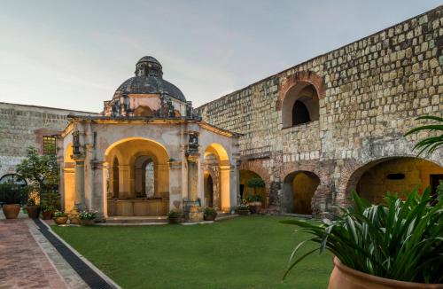 un antiguo edificio de piedra con un patio verde en Quinta Real Oaxaca, en Oaxaca City