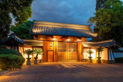 un edificio giapponese con cancello e palme di Sumiya Cuernavaca a Cuernavaca