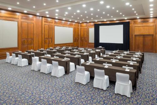 a large room with tables and chairs and a screen at Camino Real Guadalajara in Guadalajara