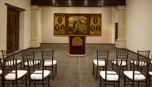 a room with chairs and a podium in a room with a painting at Quinta Real Zacatecas in Zacatecas