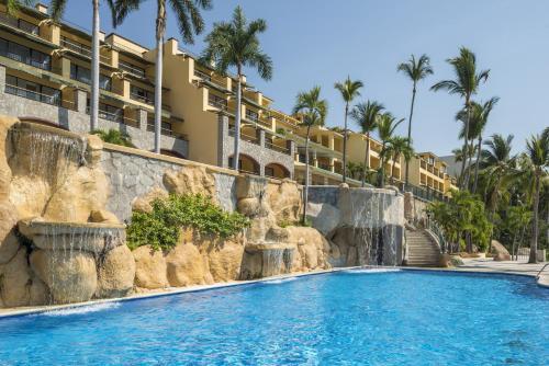 a resort pool with a waterfall and a resort at Camino Real Acapulco Diamante in Acapulco