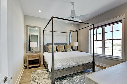 a bedroom with a canopy bed and a mirror at Sleek Beach at Palmilla Beach in Port Aransas