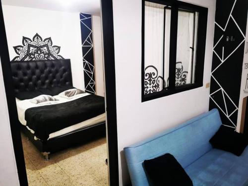 een slaapkamer met een zwart bed en een spiegel bij Hermoso apartamento en el centro histórico de San Gil I 2 in San Gil