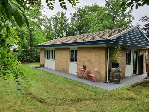 a small house with two chairs and a table at Vakantiewoning Dinkelhofje met gratis linnen in Denekamp