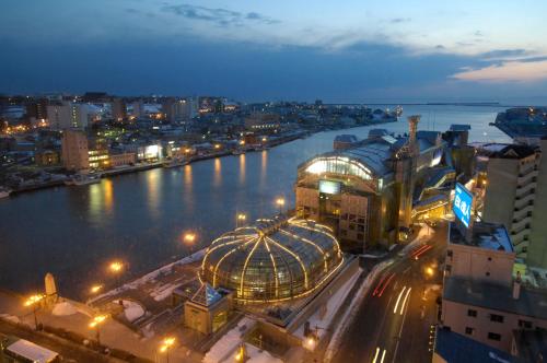 a view of a city with a river at night at Dormy Inn PREMIUM Kushiro in Kushiro