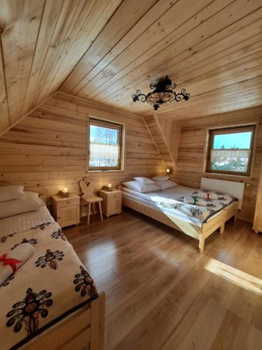 a bedroom with two beds in a wooden cabin at Domek Przekolec in Szaflary