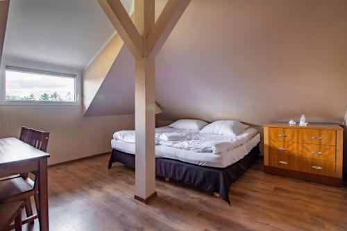 sypialnia z łóżkiem i drewnianą podłogą w obiekcie Apartamenty Wilk w Łebie
