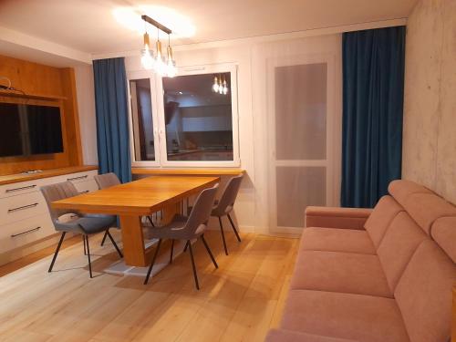 een keuken en eetkamer met een houten tafel en een bank bij Apartament Nad wierzbami in Piechowice