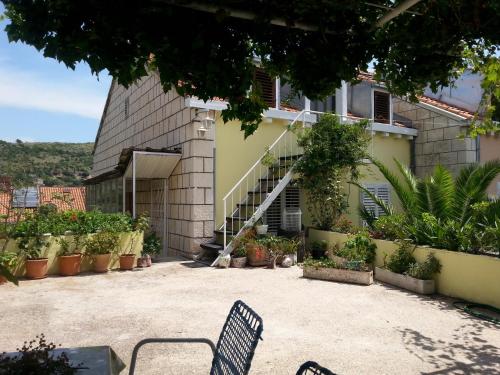 a patio with two chairs in front of a building at Hostel Saint Ursula Rooms in Dubrovnik