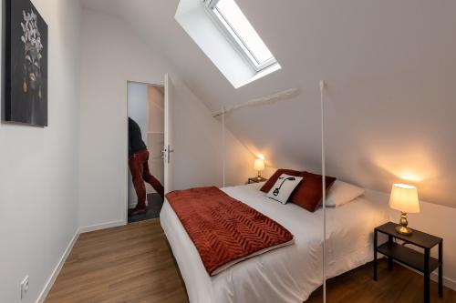 a bedroom with a bed and a skylight at Les Clés de La porte Saint-Nicolas - Parking - Centre in Beaune