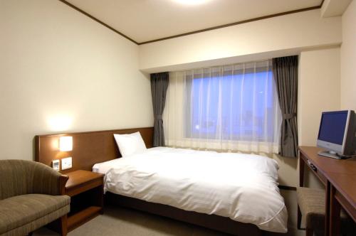 钏路Dormy Inn PREMIUM Kushiro的一间有床和窗户的酒店房间