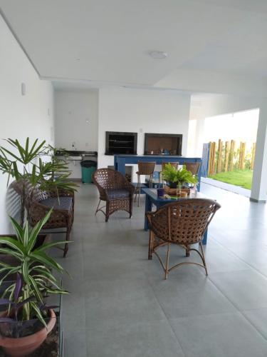 a living room with chairs and a table with plants at Bella Ciao Hospedaria in Passo de Torres