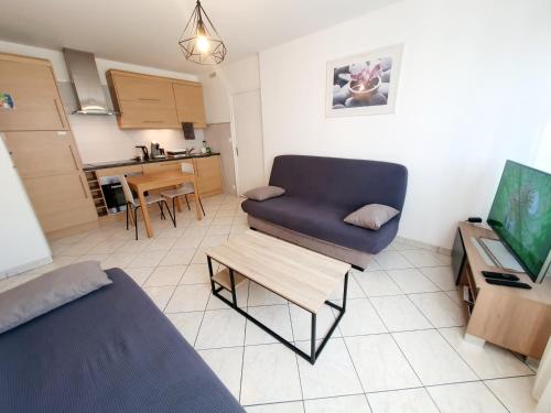 - un salon avec un canapé, une chaise et une table dans l'établissement Apart 5 personnes, 1min Gare d'Annemasse, Genève 5km, à Annemasse