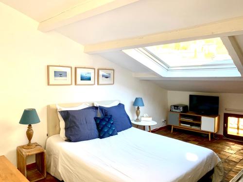 a bedroom with a large bed and a skylight at Le 1835, Studio Bleu-Coton in Moustiers-Sainte-Marie