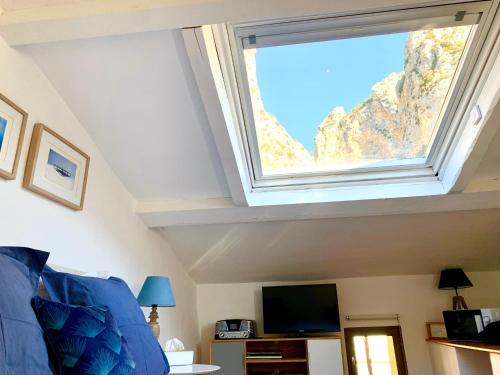 a skylight in a living room with a window at Le 1835, Studio Bleu-Coton in Moustiers-Sainte-Marie