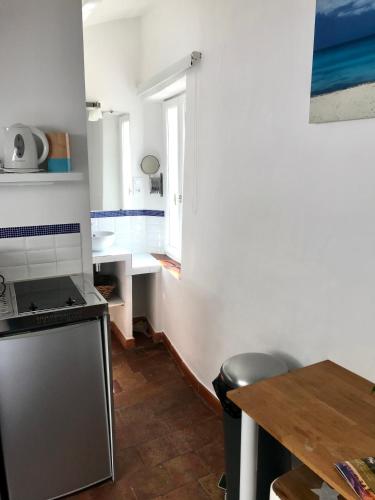 une cuisine avec une table et une cuisinière four supérieur dans l'établissement Le 1835, Studio Bleu-Coton, à Moustiers-Sainte-Marie